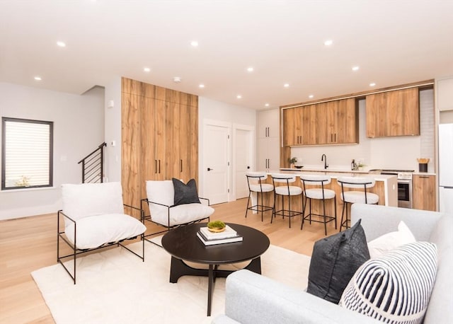 living room with light wood-style floors, stairway, and recessed lighting