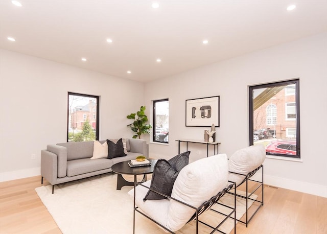 living area featuring recessed lighting, light wood finished floors, and baseboards