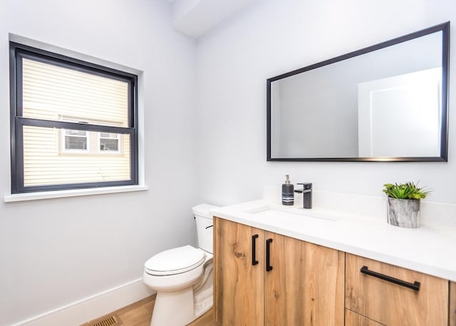 bathroom featuring vanity, baseboards, toilet, and wood finished floors