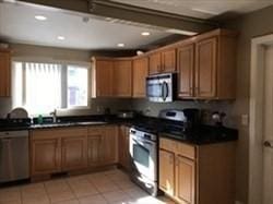 kitchen featuring appliances with stainless steel finishes, dark countertops, and brown cabinets