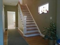 staircase featuring baseboards and wood finished floors