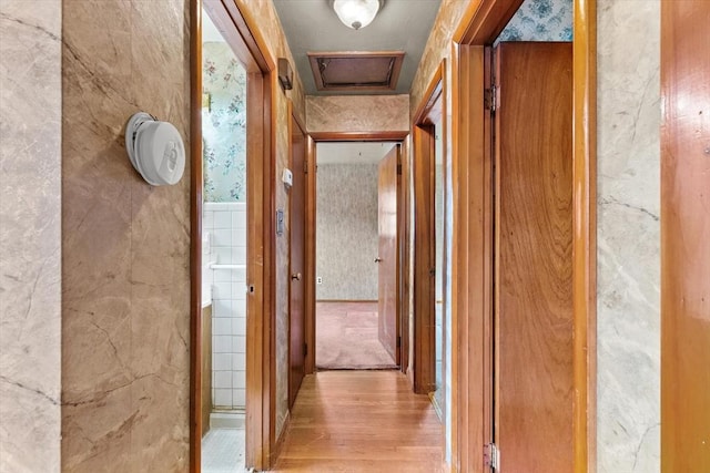 hall featuring visible vents, wood finished floors, and wallpapered walls