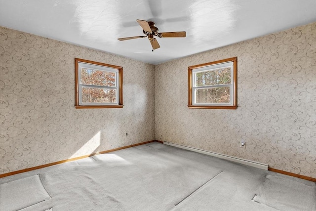 empty room featuring a baseboard heating unit, baseboards, carpet floors, and ceiling fan