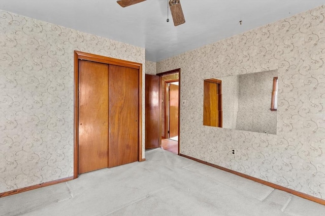 unfurnished bedroom featuring wallpapered walls, baseboards, carpet floors, and ceiling fan