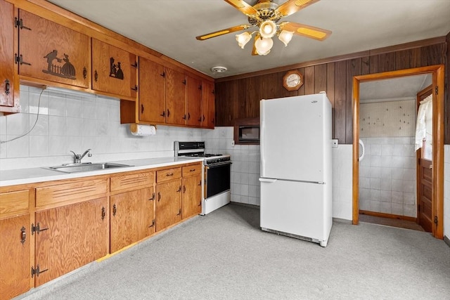 kitchen with ceiling fan, light countertops, brown cabinets, white appliances, and a sink