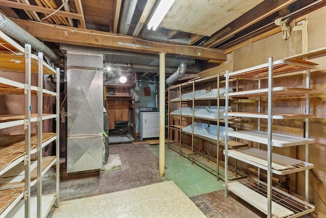 storage area featuring heating unit and washer / dryer