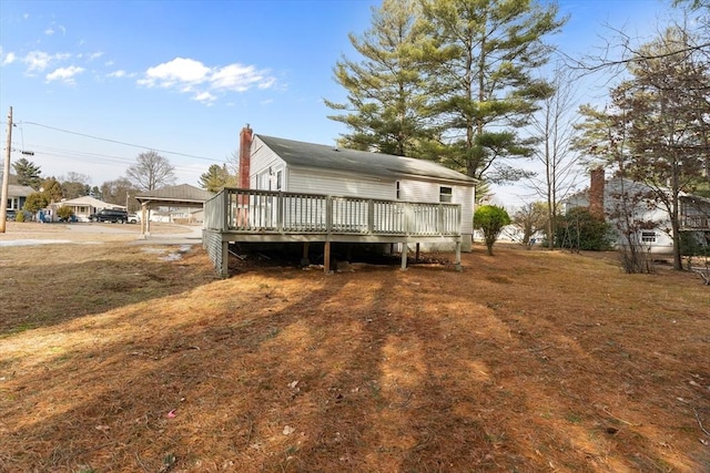 back of house featuring a chimney and a deck