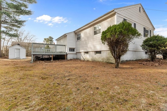 rear view of property featuring a storage shed, an outdoor structure, and a wooden deck