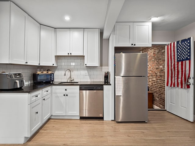 kitchen with white cabinetry, sink, light hardwood / wood-style floors, and stainless steel appliances