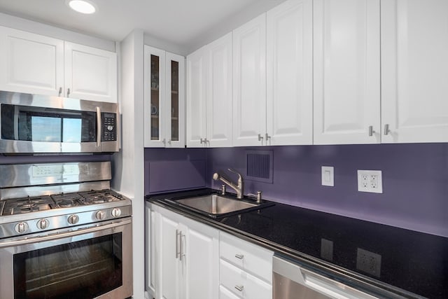 kitchen with white cabinets, appliances with stainless steel finishes, and sink