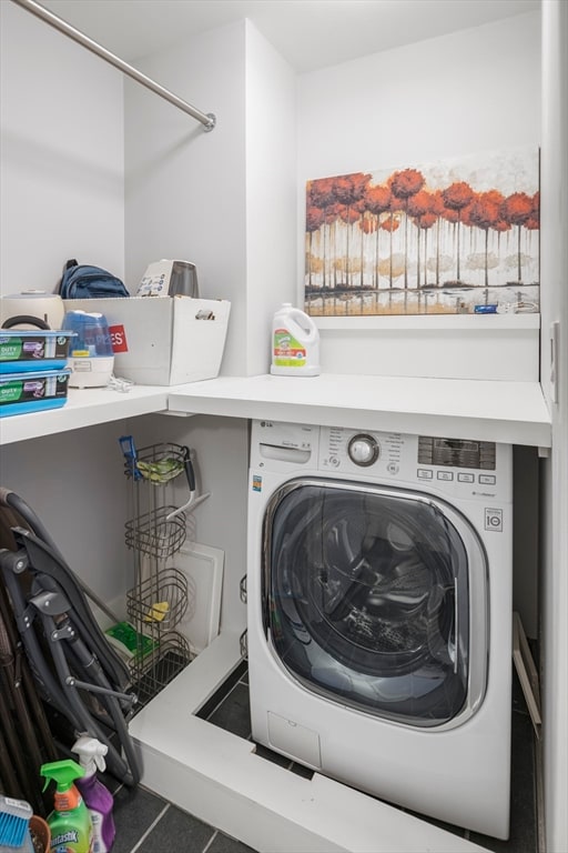 laundry area with tile patterned flooring and washer / dryer