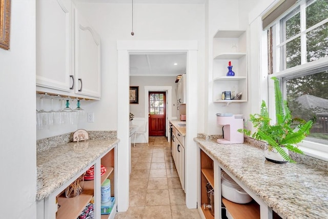 100 Melrose St Unit 100, Arlington, MA 02474 - kitchen with open shelves, white cabinets, light stone countertops, light tile patterned flooring, and built in shelves