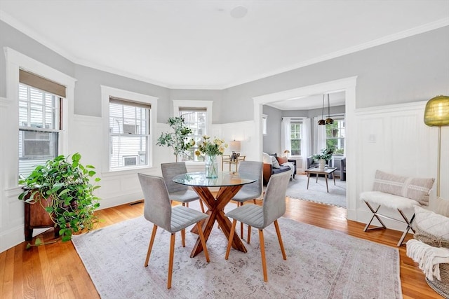 100 Melrose St Unit 100, Arlington, MA 02474 - dining area featuring a decorative wall, a wainscoted wall, light wood-style flooring, and crown molding