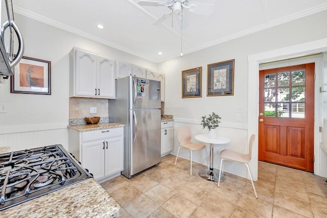 100 Melrose St Unit 100, Arlington, MA 02474 - kitchen with stainless steel appliances, a ceiling fan, crown molding, white cabinetry, and a wainscoted wall