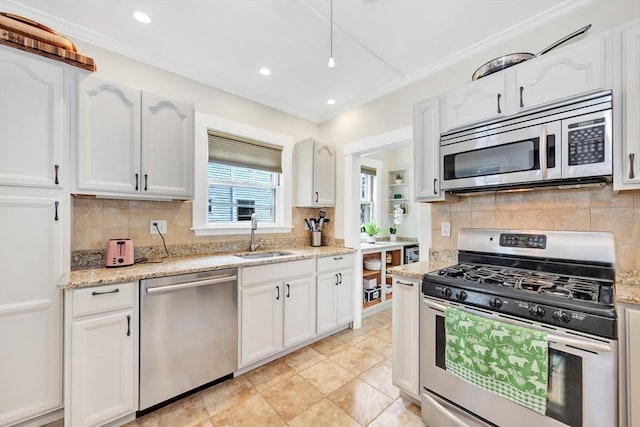 100 Melrose St Unit 100, Arlington, MA 02474 - kitchen featuring appliances with stainless steel finishes, a sink, white cabinetry, decorative backsplash, and light stone countertops