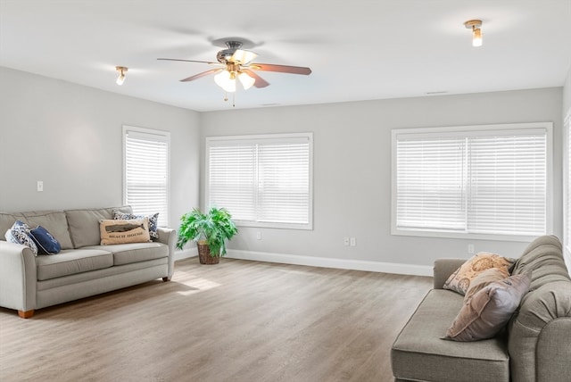 living room with ceiling fan, light hardwood / wood-style flooring, and a wealth of natural light