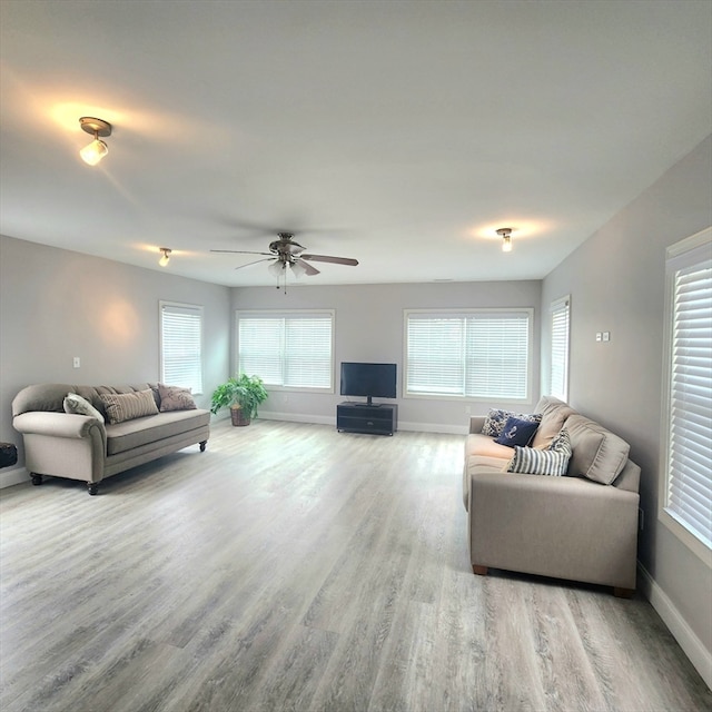 living room with light wood-type flooring and ceiling fan