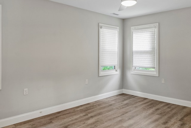 empty room with hardwood / wood-style floors and ceiling fan