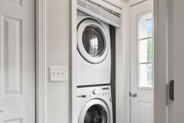 clothes washing area with stacked washer and dryer