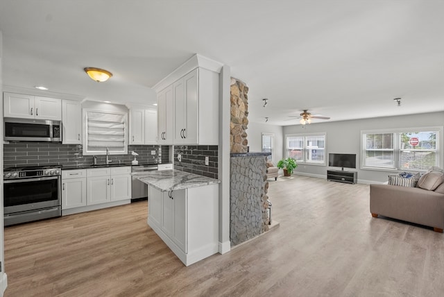 kitchen with white cabinets, stainless steel appliances, and light wood-type flooring