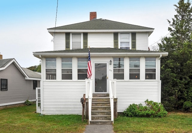 view of front of home featuring a sunroom and a front yard