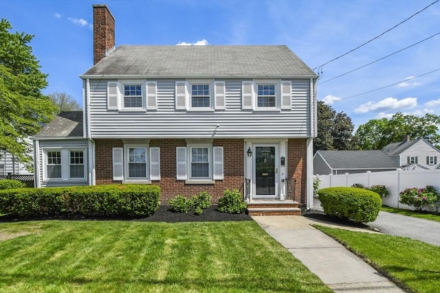 223 Warren St, Waltham, MA 02453 - colonial home featuring a chimney and brick siding