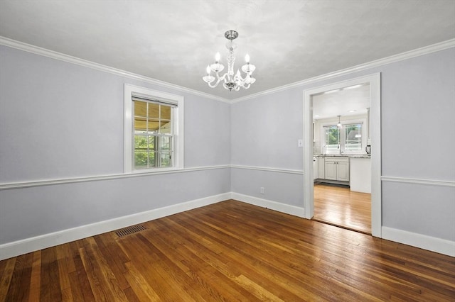 223 Warren St, Waltham, MA 02453 - spare room featuring a chandelier, wood finished floors, baseboards, and crown molding