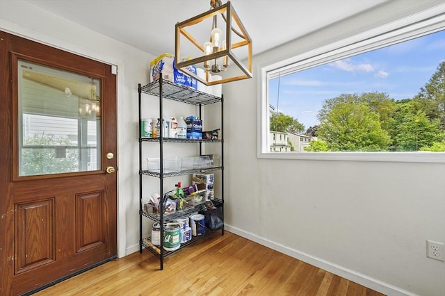 223 Warren St, Waltham, MA 02453 - doorway to outside with baseboards, a chandelier, and light wood-type flooring