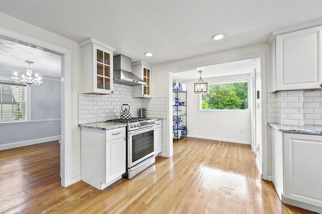 223 Warren St, Waltham, MA 02453 - kitchen with wall chimney range hood, stainless steel gas range, baseboards, light wood-style floors, and recessed lighting