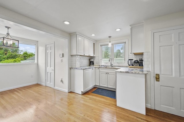 223 Warren St, Waltham, MA 02453 - kitchen featuring a sink, tasteful backsplash, white cabinetry, and recessed lighting