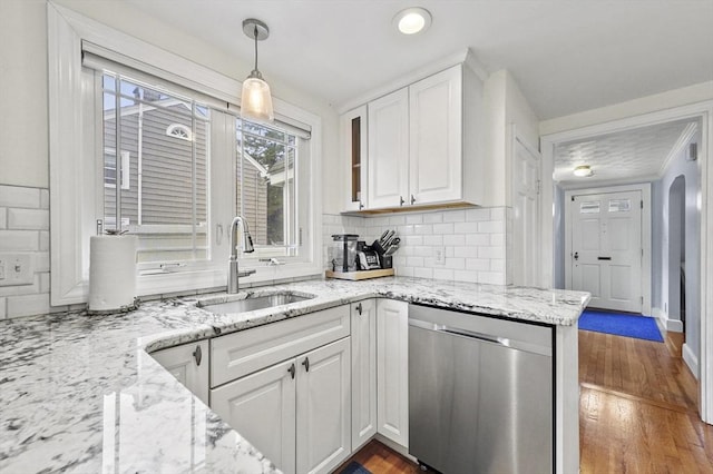223 Warren St, Waltham, MA 02453 - kitchen featuring stainless steel dishwasher, a sink, white cabinetry, and tasteful backsplash