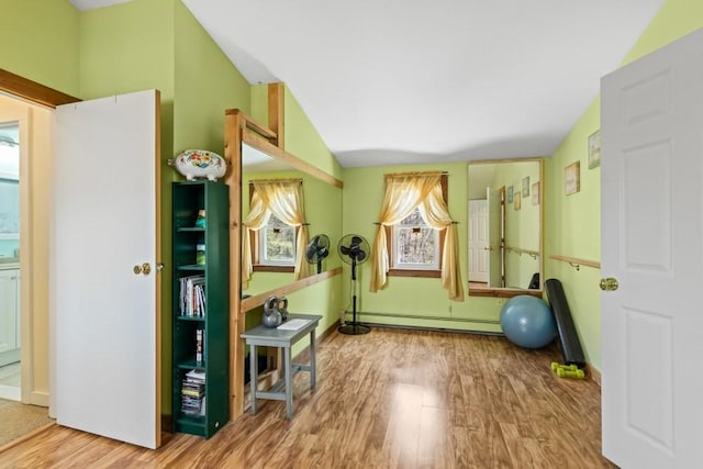 workout area featuring a baseboard heating unit and wood finished floors