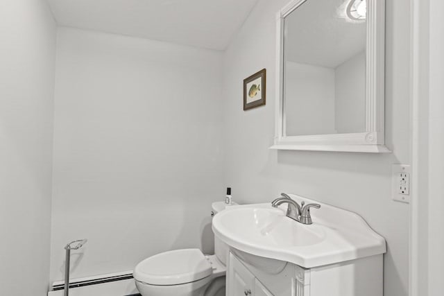 half bath with vanity, a baseboard radiator, and toilet
