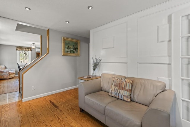 living area with baseboards, wood finished floors, and recessed lighting