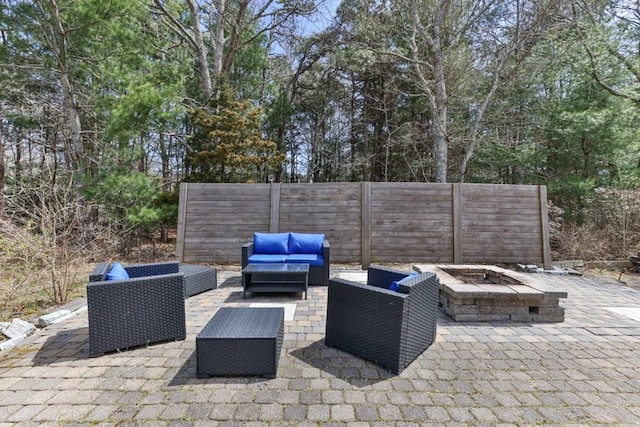 view of patio / terrace with an outdoor living space with a fire pit and fence