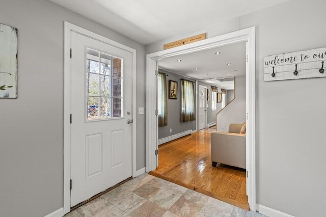 foyer with a baseboard radiator and baseboards