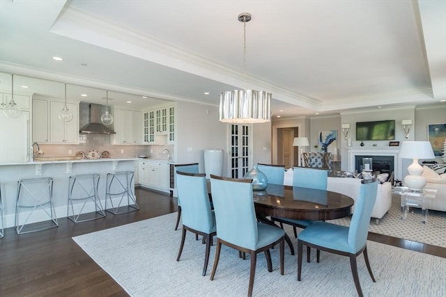 dining room featuring crown molding, wood-type flooring, and a tray ceiling