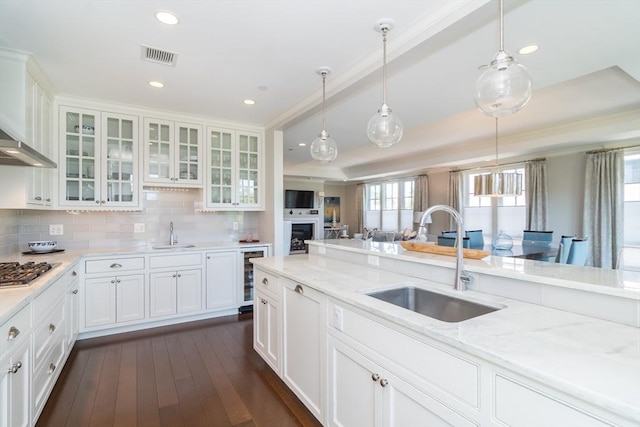 kitchen featuring light stone countertops, white cabinetry, and sink