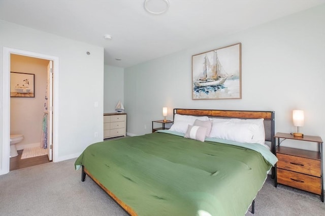 bedroom featuring light carpet, ensuite bathroom, and baseboards