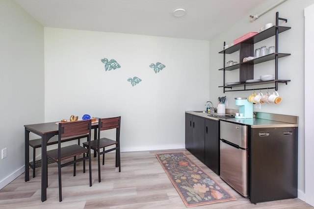 bar featuring a dry bar, a sink, freestanding refrigerator, and baseboards