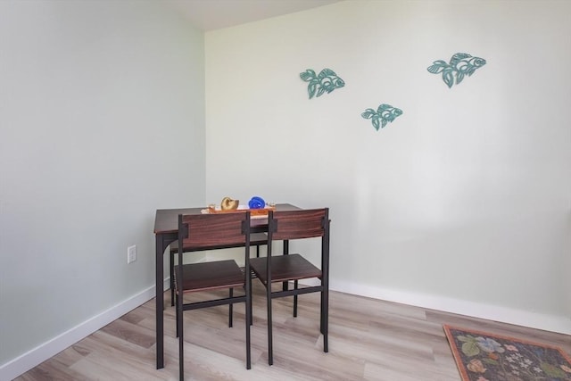 dining area with light wood finished floors and baseboards