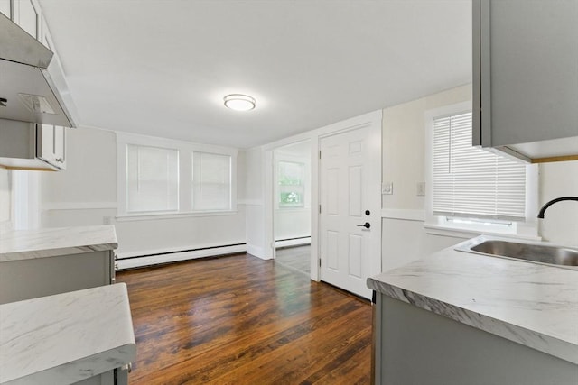 357 Granite St, Quincy, MA 02169 - kitchen with under cabinet range hood, baseboard heating, gray cabinetry, a baseboard radiator, and dark wood-style flooring
