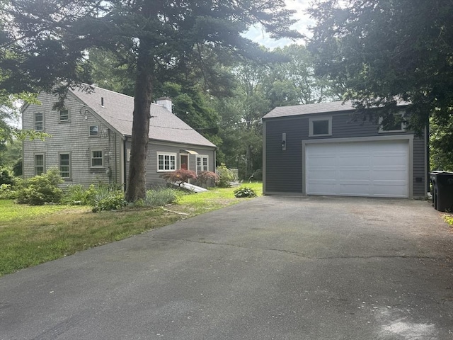 view of side of property featuring a garage and a lawn