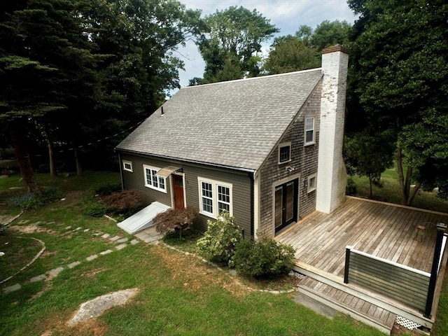 rear view of property featuring a deck and a lawn