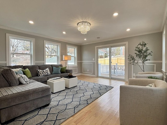 living room featuring recessed lighting, wainscoting, light wood-type flooring, and ornamental molding