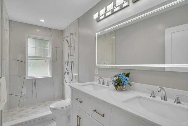 full bathroom with a sink, a marble finish shower, toilet, and double vanity