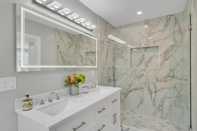 full bath with a sink, a marble finish shower, recessed lighting, and double vanity