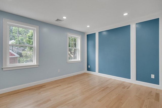 unfurnished room with recessed lighting, wood finished floors, visible vents, and baseboards