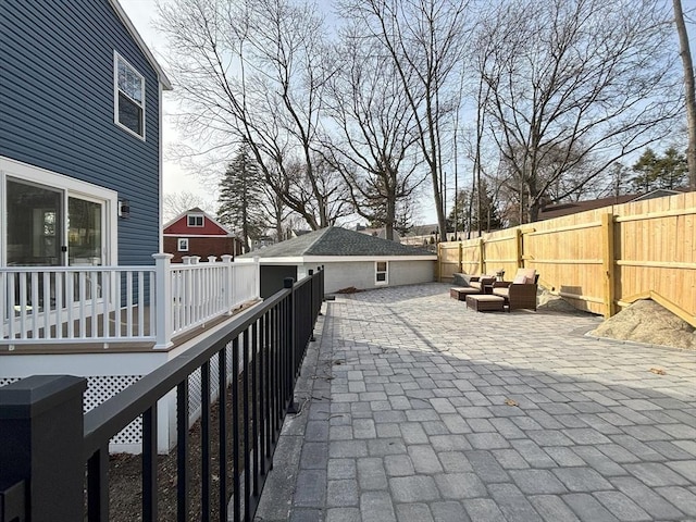 view of patio featuring a deck, an outdoor living space, and a fenced backyard