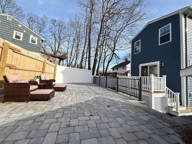 view of patio / terrace with an outdoor living space, a deck, and a fenced backyard